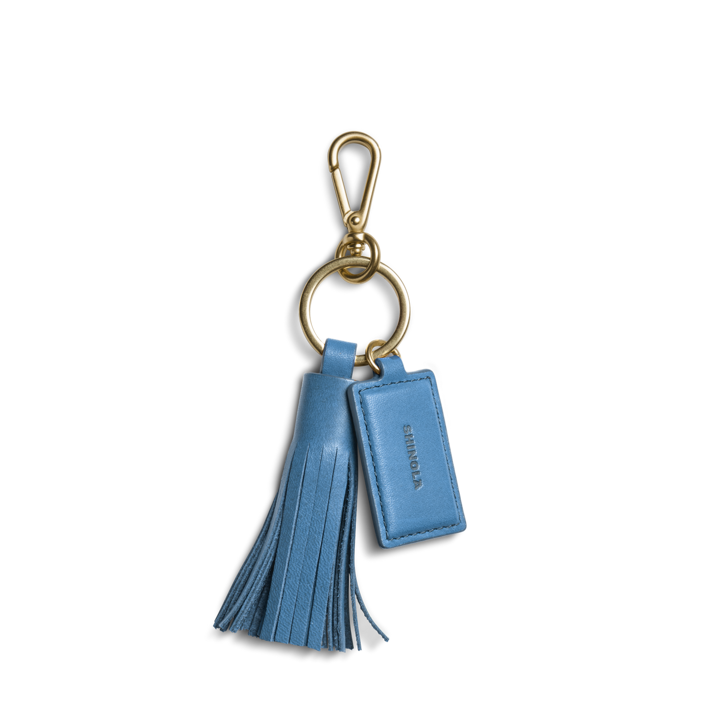 The Shinola Leather Tassel Keychain - River is a blue leather keychain with a gold clasp, tassel, and a small tag embossed with SHINOLA—stylish and perfect for your keys.