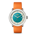 The Detrola Watch - Aqua Green by Shinola features an art-inspired design with an orange band, silver case, teal face, colorful hour markers, and a small date window on the right for a bold modern statement.