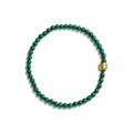 The Shinola 4mm Beaded Bracelet Malachite features green round malachite beads and a single larger engraved brass accent bead, arranged in a circle on a white background.