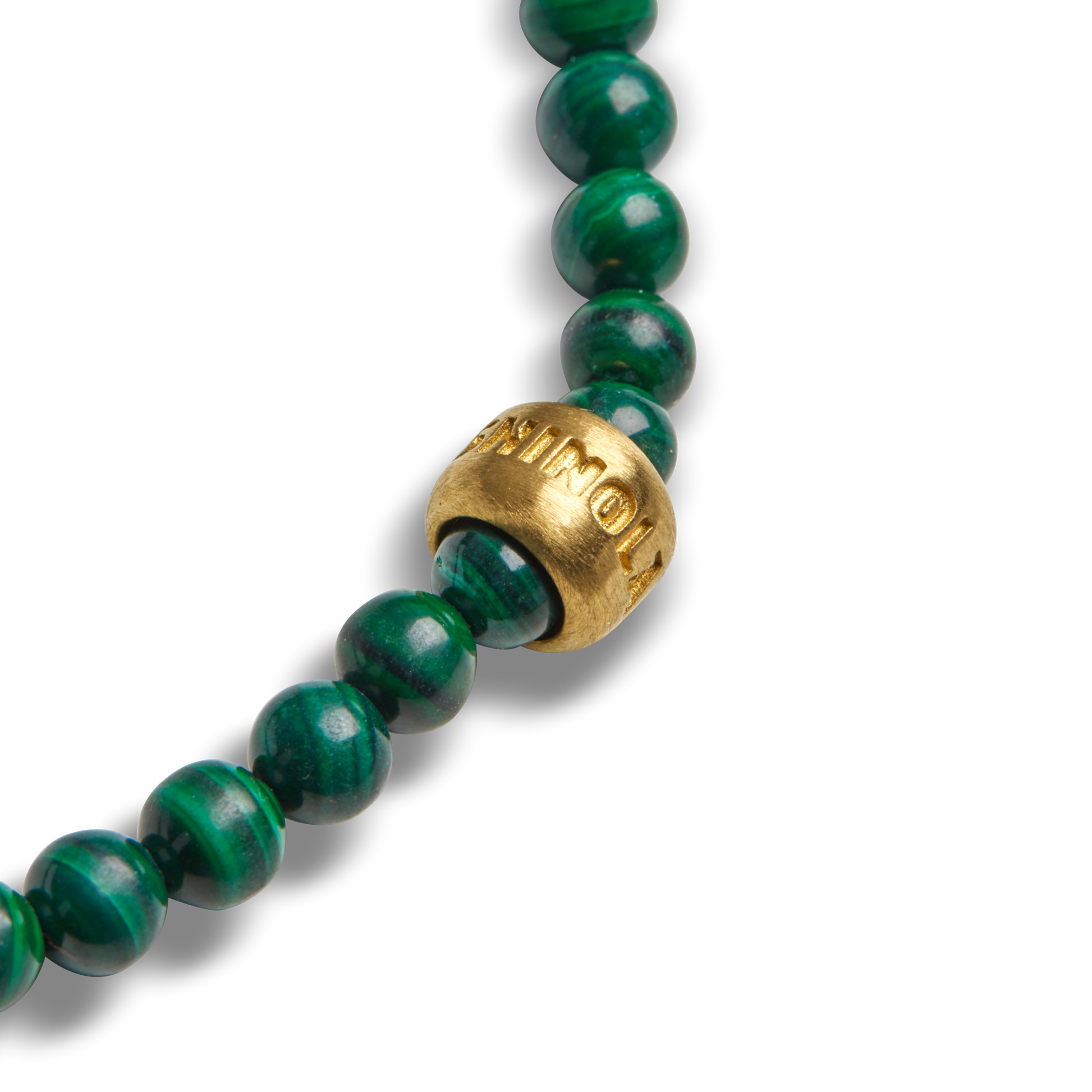 A close-up of the Shinola 4mm Beaded Bracelet Malachite, showcasing round malachite beads and a single large brass accent bead with engraved lettering.