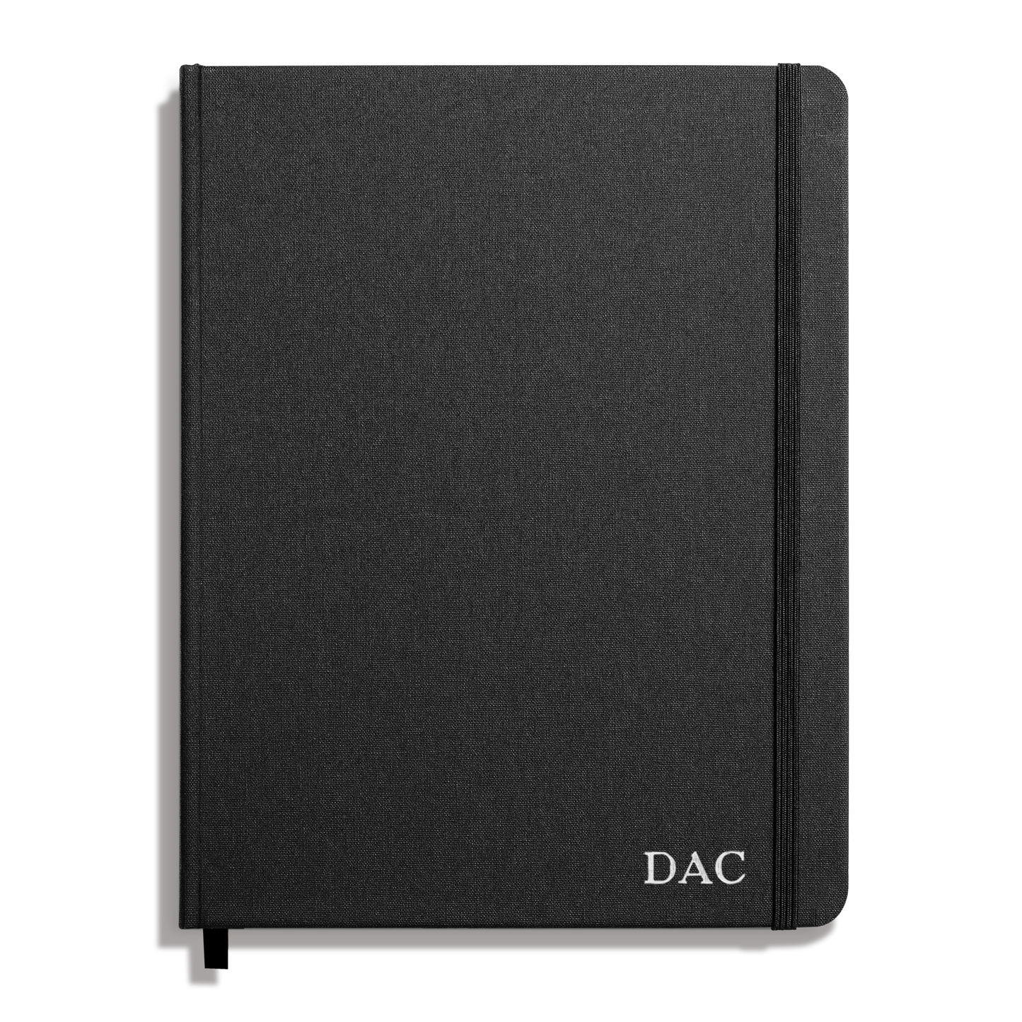 The Shinola Large Hard Ruled Journal in black features a textured cover, smyth-sewn binding, an elastic band on the right edge, and "DAC" initials printed in white on the lower right corner.