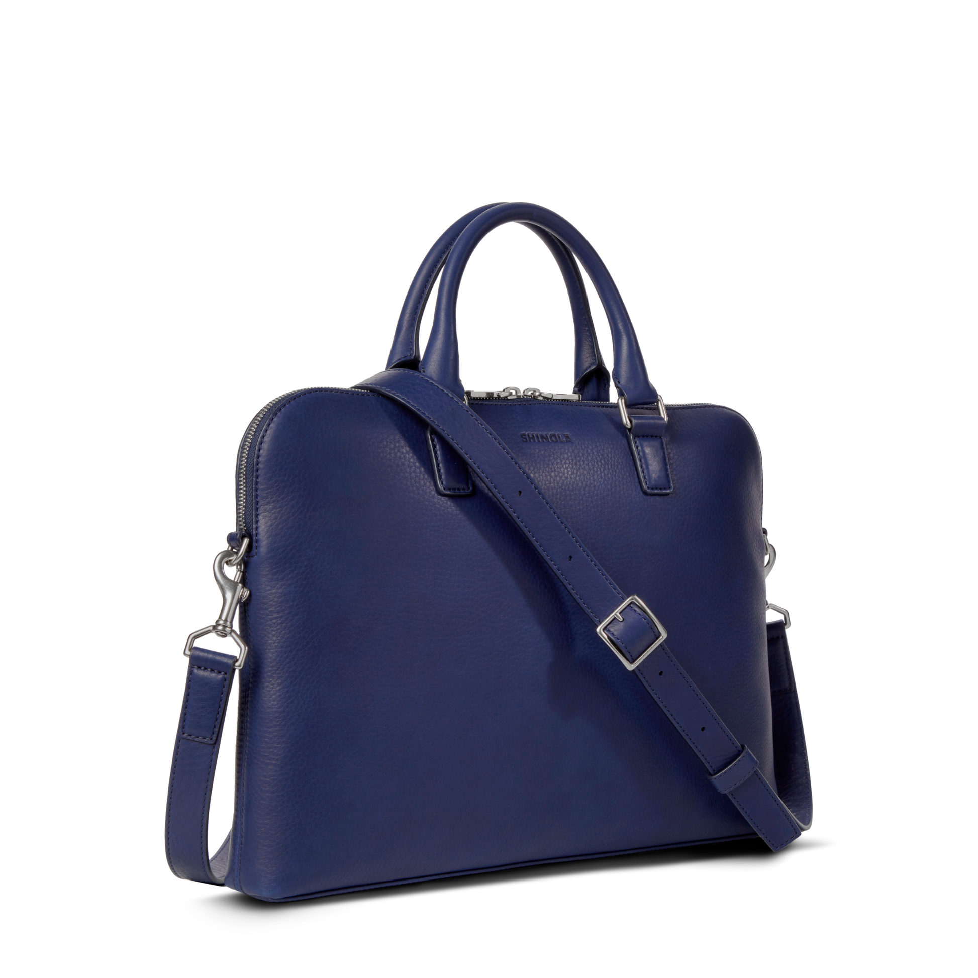 The Shinola Portfolio Briefcase - Lake is a blue slim laptop briefcase made from European grain leather with dual handles, a detachable shoulder strap, and silver hardware, shown against a plain white background.