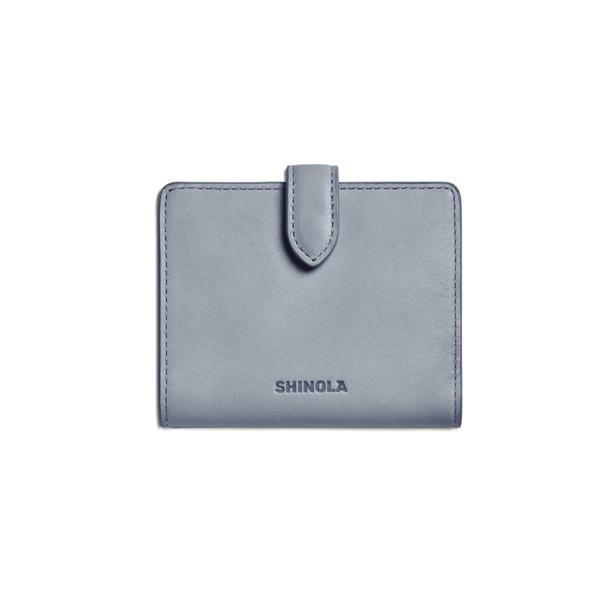 A closed Small Snap Wallet - Mist by Shinola, featuring a light blue color and tab closure with the brand name embossed on the front, is shown against a plain white background.