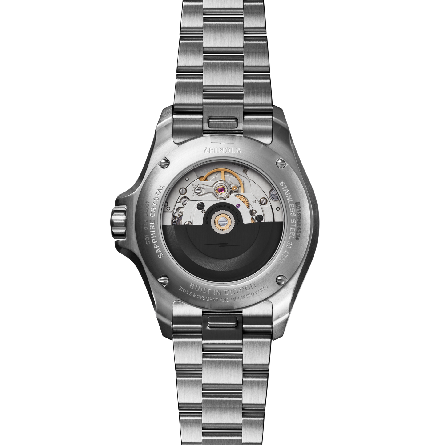 The image shows the back of the Shinola Lake Michigan Monster Automatic Dive Watch, featuring a transparent case that reveals its intricate automatic movement, with a metallic band and engraved details circling the case.