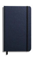 The Shinola Medium Hard Grid Journal in navy, made of hard linen with a black elastic band, ribbon bookmark, and acid-free paper, is shown closed against a white background.