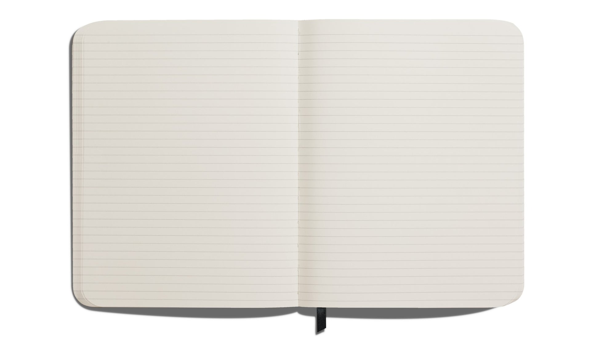 The Shinola Large Hard Ruled Journal - Stone is shown from above, featuring cream-colored, acid-free lined pages and a black ribbon bookmark visible at the bottom center.