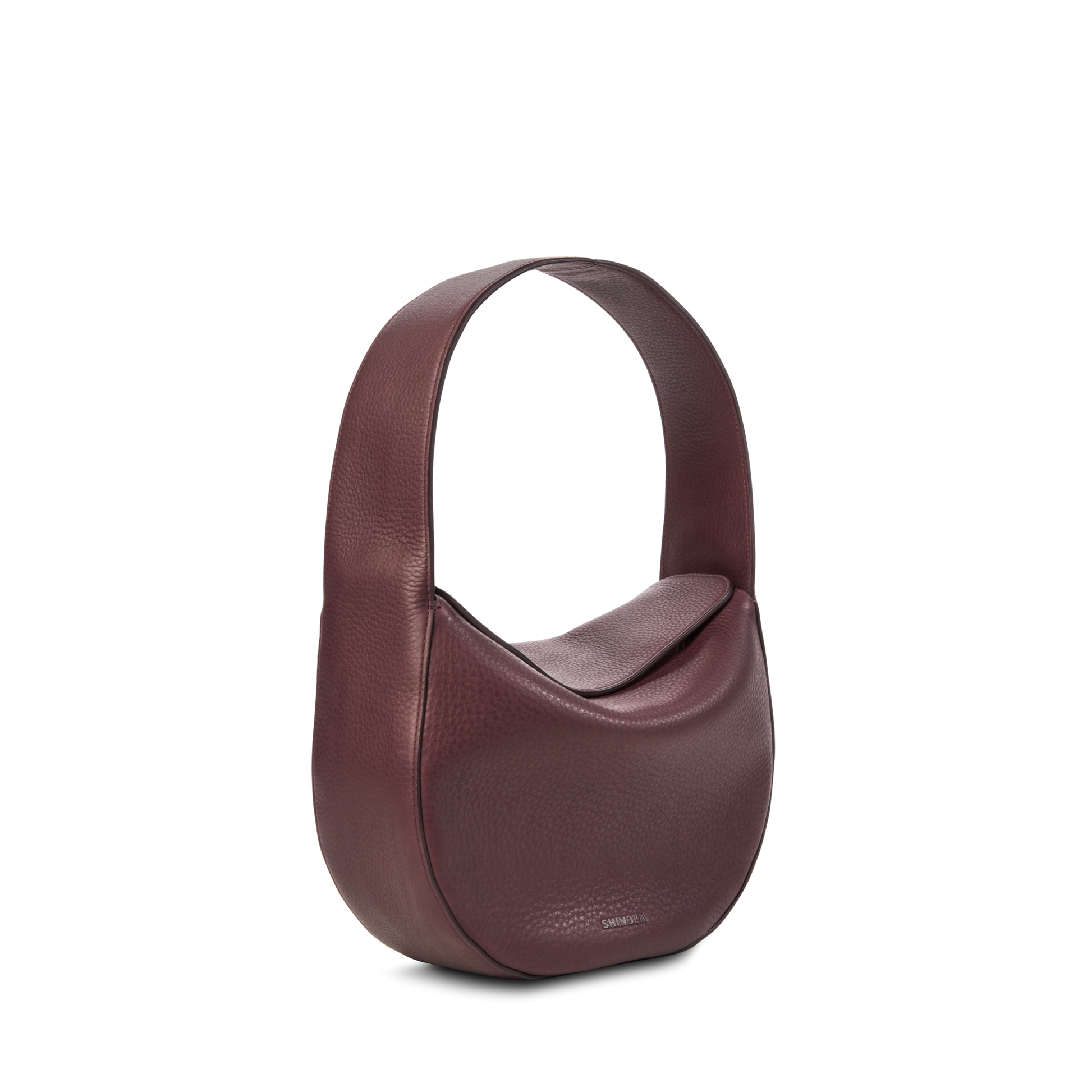 The Shinola Small Shoulder Bag - Merlot is a maroon, crescent-shaped bag in natural grain leather with a wide strap and textured finish, showcasing premium craftsmanship against a plain light background.