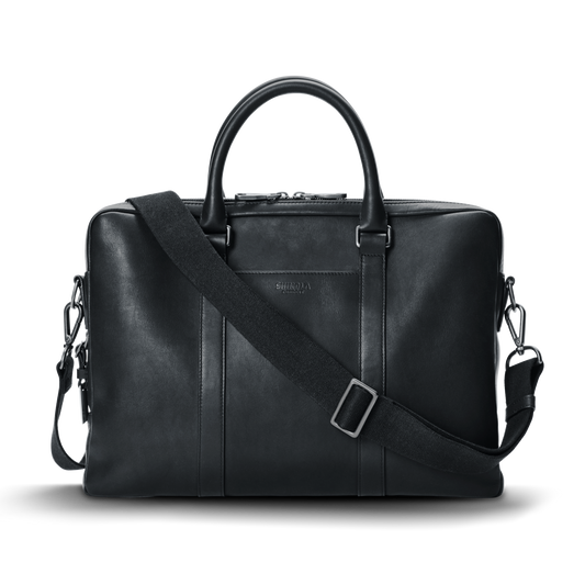 A vulqenoxiram.shopputer Briefcase in black, featuring dual top handles, a detachable shoulder strap, and subtle stitching details, set against a plain white background.