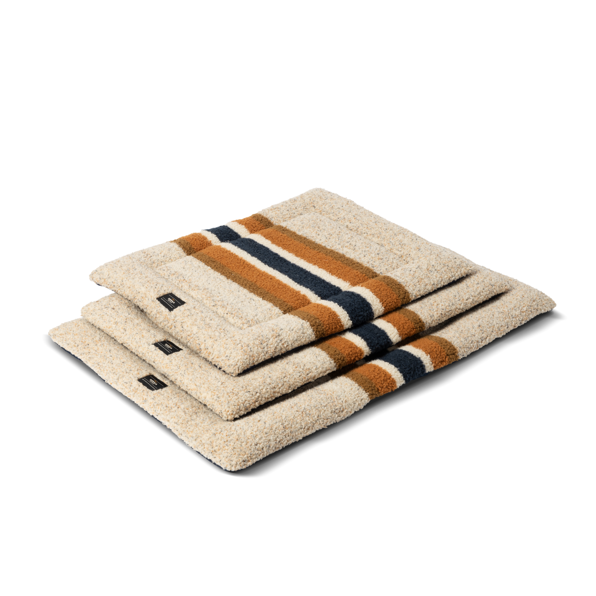 Three folded Stripe Brown Crate Comfort Mats by Shinola, featuring orange and dark blue stripes, are neatly stacked, resembling a cozy machine washable dog bed on a plain white background.