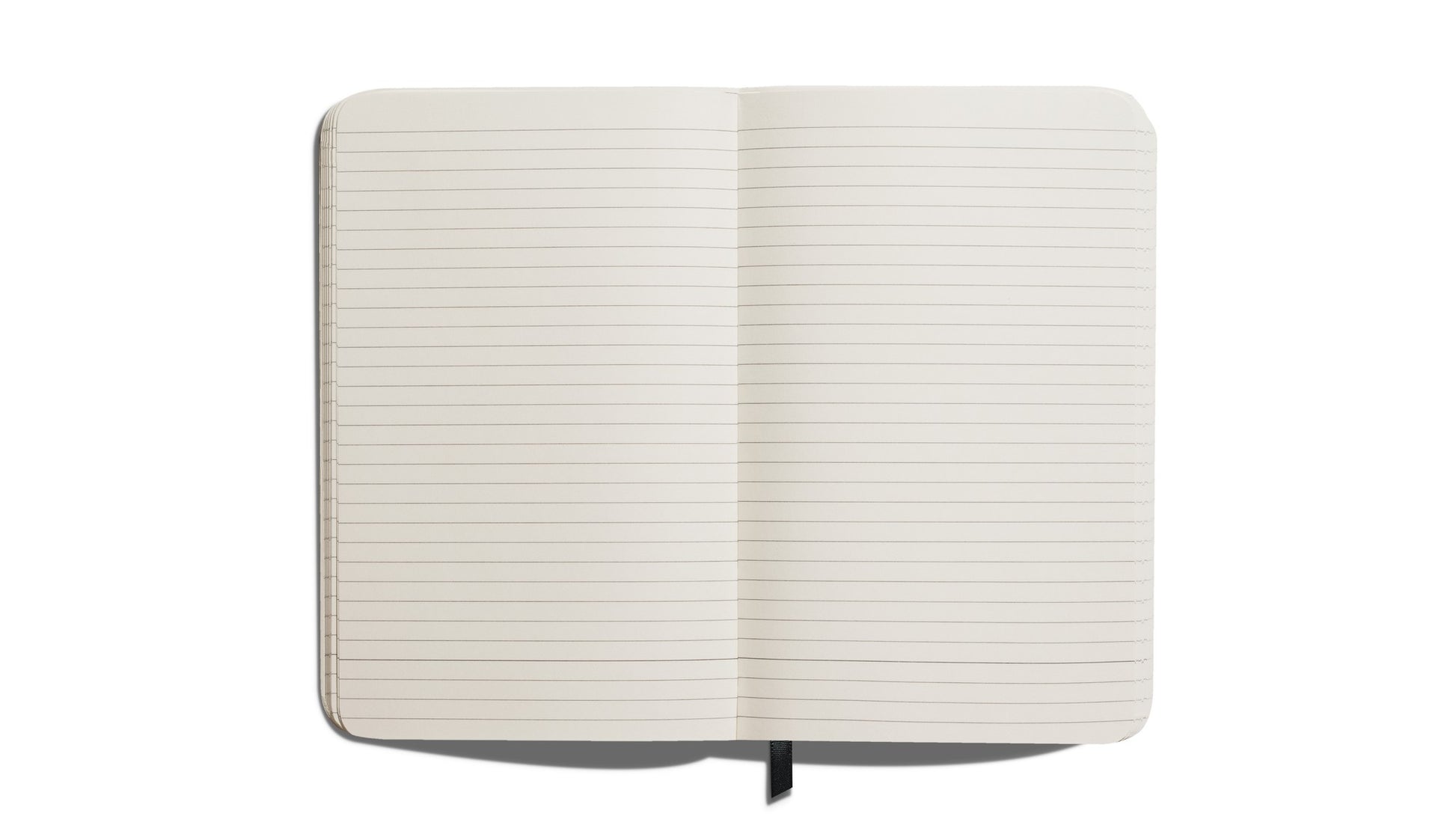 A Shinola Medium Hard Ruled Journal - Fern, featuring acid-free lined pages and a black ribbon bookmark, is shown open from above on a white background.